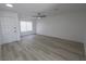 Spacious living room featuring wood-look flooring, a ceiling fan, and a large window providing natural light at 134 Saint Albans Dr, Henderson, NV 89015