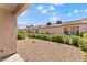 This backyard has a private gravel-covered yard with mature landscaping at 1411 Di Blasi Dr # 104, Las Vegas, NV 89119