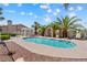 Community pool surrounded by palm trees and lounge area seating at 1411 Di Blasi Dr # 104, Las Vegas, NV 89119