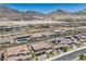 Wide aerial view of community featuring terracotta roofs, lush landscaping, and mountain views at 201 Carmel Sky St, Las Vegas, NV 89138