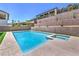 Sparkling backyard pool and spa with retaining wall and turf at 201 Carmel Sky St, Las Vegas, NV 89138