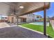 Covered outdoor kitchen with fan overlooks backyard pool at 201 Carmel Sky St, Las Vegas, NV 89138