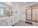 Modern bathroom with double vanity, decorative floor tile, and frameless glass shower at 201 Carmel Sky St, Las Vegas, NV 89138