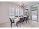 Elegant dining room with a modern chandelier and sliding glass doors to the outdoor patio at 201 Carmel Sky St, Las Vegas, NV 89138