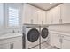 Well-lit laundry room has built-in cabinets and modern appliances at 201 Carmel Sky St, Las Vegas, NV 89138
