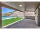 Covered outdoor patio with fan overlooks backyard pool and terraced landscaping at 201 Carmel Sky St, Las Vegas, NV 89138