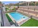Backyard view of pool and elevated patio with fence that is surrounded by artificial turf at 201 Carmel Sky St, Las Vegas, NV 89138