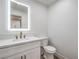 Half bath featuring a sleek vanity with a modern lighted mirror and updated fixtures at 2107 Fountain Springs Dr, Henderson, NV 89074