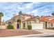 Attractive two-story home featuring a tile roof, arched entry, blue door, and mature landscaping at 2107 Fountain Springs Dr, Henderson, NV 89074