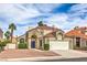 Charming two-story home with a tile roof, blue front door, and a well-manicured landscape at 2107 Fountain Springs Dr, Henderson, NV 89074