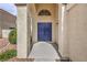 Inviting entrance with double blue doors, textured stucco, and manicured landscaping at 2107 Fountain Springs Dr, Henderson, NV 89074
