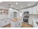 Modern white kitchen with stainless steel appliances, butcher block island, and plenty of cabinet space at 2107 Fountain Springs Dr, Henderson, NV 89074