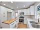 Modern kitchen features white cabinets, stainless steel appliances, and wood-topped island at 2107 Fountain Springs Dr, Henderson, NV 89074