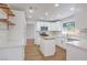 Bright kitchen boasts white cabinets, quartz countertops, stainless steel appliances, and center island at 2107 Fountain Springs Dr, Henderson, NV 89074