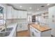 Bright kitchen with white cabinets, gold hardware, quartz countertops, and stainless steel sink at 2107 Fountain Springs Dr, Henderson, NV 89074