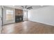 Open living room with wood-look flooring, a brick fireplace, large windows, and a ceiling fan at 2107 Fountain Springs Dr, Henderson, NV 89074