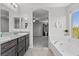 Bright bathroom features a soaking tub, double vanity with granite countertop, and natural light at 2276 Sky Island Dr, Henderson, NV 89002