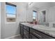 A well-lit bathroom features double sinks with granite counters and views from a window at 2276 Sky Island Dr, Henderson, NV 89002