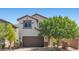 Charming two-story home featuring a brown garage door, stone accents, and manicured landscaping at 2276 Sky Island Dr, Henderson, NV 89002