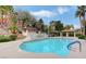 Community pool with tiled patio, lounge area, waterfalls, and lush landscaping at 231 W Horizon Ridge Pkwy # 1228, Henderson, NV 89012