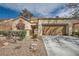 Inviting home with a two-car garage, decorative rock landscaping and a charming gated front entryway at 2520 Palmridge Dr, Las Vegas, NV 89134