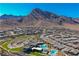 Panoramic aerial view of the community with mountains, manicured landscaping, pools, and modern clubhouse at 2601 Nevada Agave Ln, Las Vegas, NV 89138