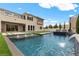 Luxury backyard with a sparkling pool, manicured turf, and an attached home with many large windows at 2601 Nevada Agave Ln, Las Vegas, NV 89138