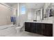 Bright bathroom with a shower over tub, dark wood vanity, and white countertop at 2601 Nevada Agave Ln, Las Vegas, NV 89138