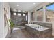 Modern bathroom with soaking tub, a glass-enclosed shower, and large windows showcasing mountain views at 2601 Nevada Agave Ln, Las Vegas, NV 89138