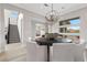 Elegant dining room with contemporary chandelier, large windows, and a stylish table setting for sophisticated gatherings at 2601 Nevada Agave Ln, Las Vegas, NV 89138
