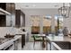 A modern dining area showcases a view of the backyard, paired with dark wood cabinetry and stone countertops at 2601 Nevada Agave Ln, Las Vegas, NV 89138