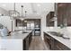 Open-concept kitchen features an island, stainless steel appliances, dark wood cabinets and modern lighting at 2601 Nevada Agave Ln, Las Vegas, NV 89138