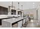 A modern kitchen features an island with barstool seating, pendant lighting and stainless steel appliances at 2601 Nevada Agave Ln, Las Vegas, NV 89138