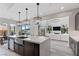 Modern kitchen features dark wood cabinets, stainless steel appliances and an island with barstool seating at 2601 Nevada Agave Ln, Las Vegas, NV 89138