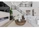 A cozy living room with a modern fireplace, white sofas, and access to upper floors via iron-railed staircase at 2601 Nevada Agave Ln, Las Vegas, NV 89138