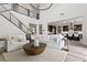 Open-concept living area with a staircase, modern lighting, sleek railings, and a glimpse of the kitchen at 2601 Nevada Agave Ln, Las Vegas, NV 89138