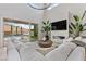 Bright living room with high ceilings, modern fireplace, comfortable white sofas, and views of the pool at 2601 Nevada Agave Ln, Las Vegas, NV 89138