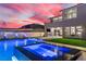 Outdoor pool and spa next to a modern two-story home, enhanced with artificial turf and a built-in outdoor kitchen at 2601 Nevada Agave Ln, Las Vegas, NV 89138
