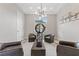 Bright sitting room boasts modern light fixture and stylish decor, with neutral tones and ample seating at 2601 Nevada Agave Ln, Las Vegas, NV 89138
