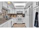 Compact kitchen featuring white cabinets, a skylight, and modern appliances at 2749 Heritage Cir, Las Vegas, NV 89121