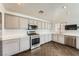 Bright kitchen with stainless steel appliances, gray cabinetry, and wooden-look herringbone flooring at 2761 Red Vista Ct, Henderson, NV 89074