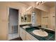 Bathroom features a double sink vanity with tile countertops and large mirror at 335 Greenbriar Townhouse Way, Las Vegas, NV 89121