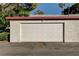 Exterior view of the garage featuring a white garage door and stucco walls at 335 Greenbriar Townhouse Way, Las Vegas, NV 89121