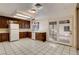 View of the kitchen featuring white tile flooring, dark cabinets, and a glass door leading to the backyard at 335 Greenbriar Townhouse Way, Las Vegas, NV 89121