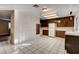 The kitchen features a textured white brick wall and a view into a living space with carpeting at 335 Greenbriar Townhouse Way, Las Vegas, NV 89121