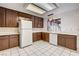 Bright kitchen featuring dark cabinetry, white appliances, white countertops, and tile flooring at 335 Greenbriar Townhouse Way, Las Vegas, NV 89121