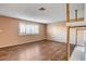 Bright living room featuring wood floors, a large window, and brick fireplace with gold accents at 335 Greenbriar Townhouse Way, Las Vegas, NV 89121
