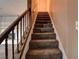 Carpeted staircase with wood railing leading to the upper level of the home at 335 Greenbriar Townhouse Way, Las Vegas, NV 89121
