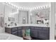 Bathroom with dual sinks, shower with glass doors, large mirror and modern fixtures at 3632 Julia Waldene Ct, Las Vegas, NV 89129