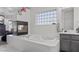 Bright bathroom featuring a large soaking tub, black cabinets, unique fireplace and shower at 3632 Julia Waldene Ct, Las Vegas, NV 89129